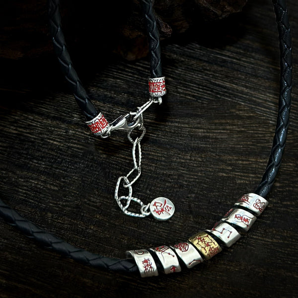 Close-up view of the black leather cord necklace against a dark wooden background, showcasing the cluster of sliding silver star beads and an adjustable extension chain with a protective round tag.