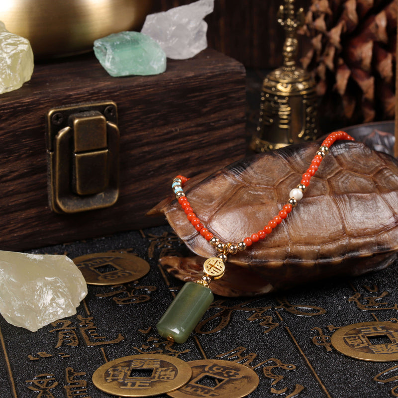 The natural red agate and Hetian jade protection amulet bracelet draped over a traditional turtle shell on a dark textured table mat, optimized as modern Zen fashion and mindfulness jewelry for stress relief.